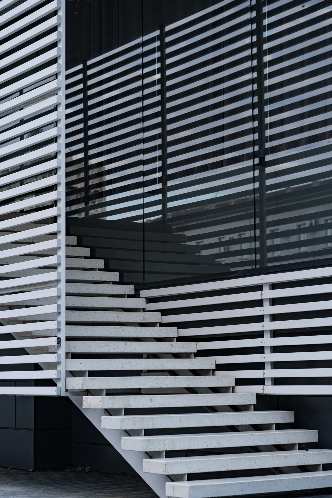 Details des Geländers und der Treppen eines modernen Gebäudes sowie Schattenreflexion auf Fenstern