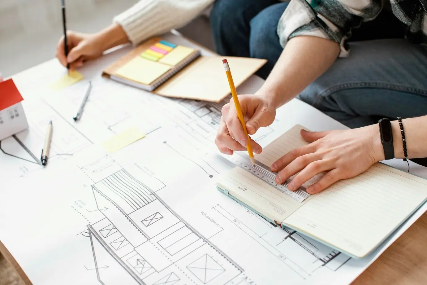 Nahaufnahme eines Paares beim Schreiben mit Bleistiften.